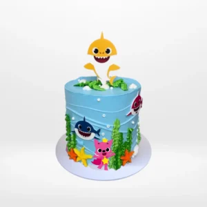 Babyshark Cake with Waves | Best Cake Shop Birmingham, The Cravery Babyshark Cake with Waves, themed blue cake with sea-inspired decorations and Baby Shark characters, from the best cake shop in Birmingham
