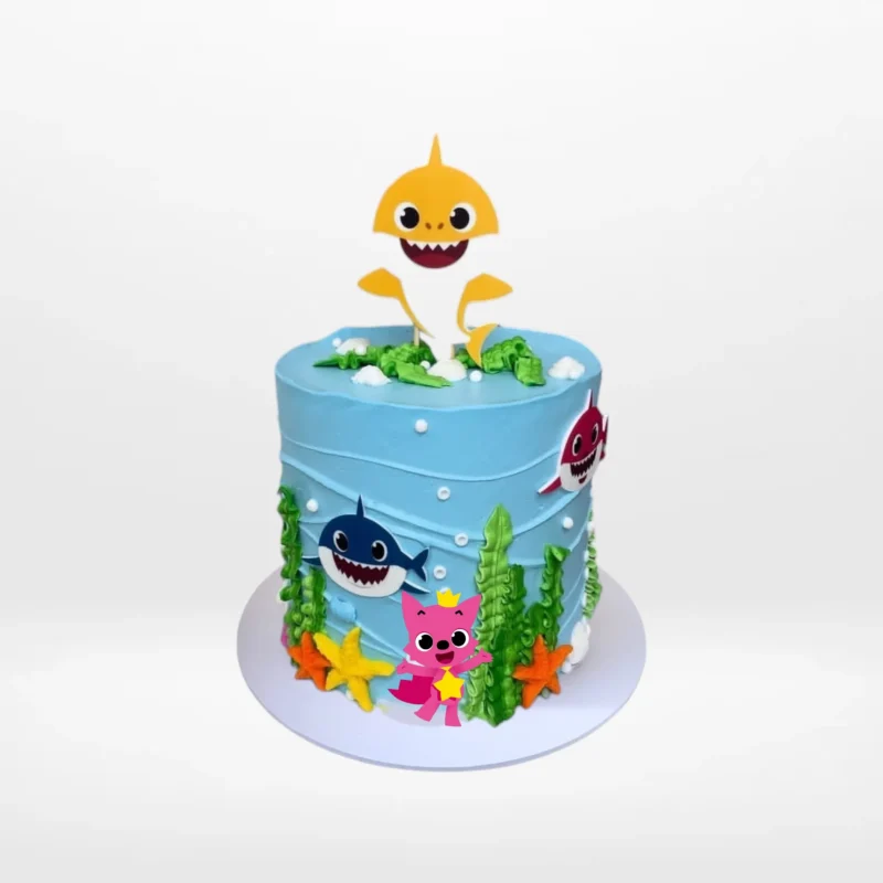 Babyshark Cake with Waves | Best Cake Shop Birmingham, The Cravery Babyshark Cake with Waves, themed blue cake with sea-inspired decorations and Baby Shark characters, from the best cake shop in Birmingham