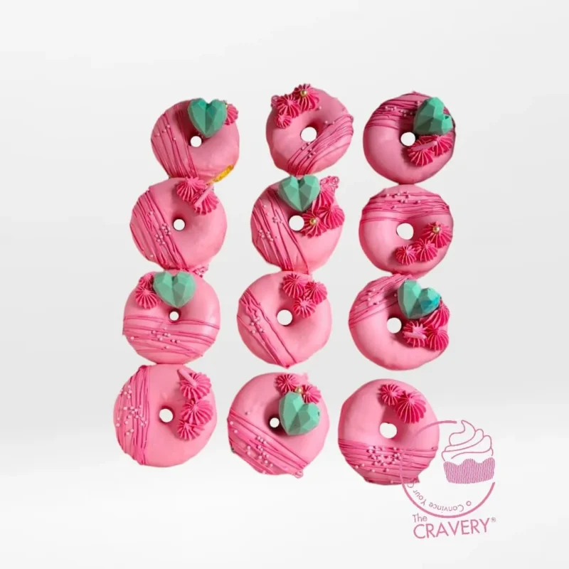Pink cake doughnuts decorated with smooth pink icing from a cake shop in Birmingham.